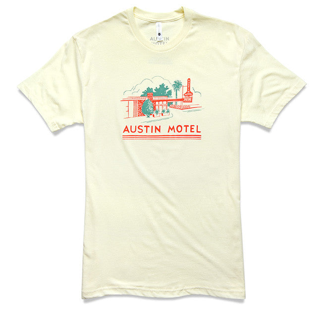 A cream t-shirt with a colorful illustration of the Austin Motel building and the text 'AUSTIN MOTEL' printed across the chest.